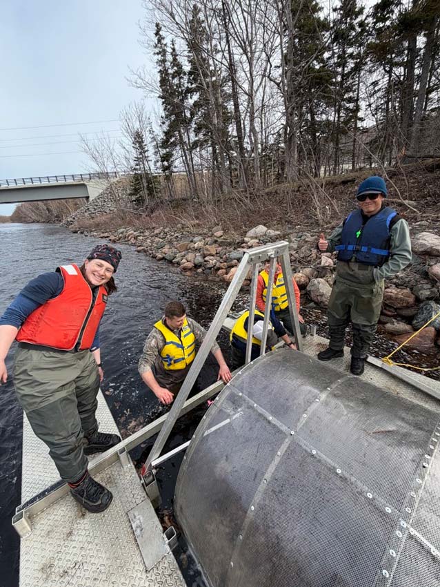 ASF's Kate Gingles (left) and Jordan Condon work with CRSA staff to construct a smolt wheel on the Chéticamp River. Photo: Matt Russell 