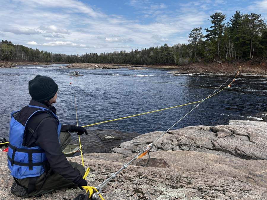 Taylor Pinette adjusts the Nepisiguit smolt wheel position as the water levels recede. Photo: Jordan Condon