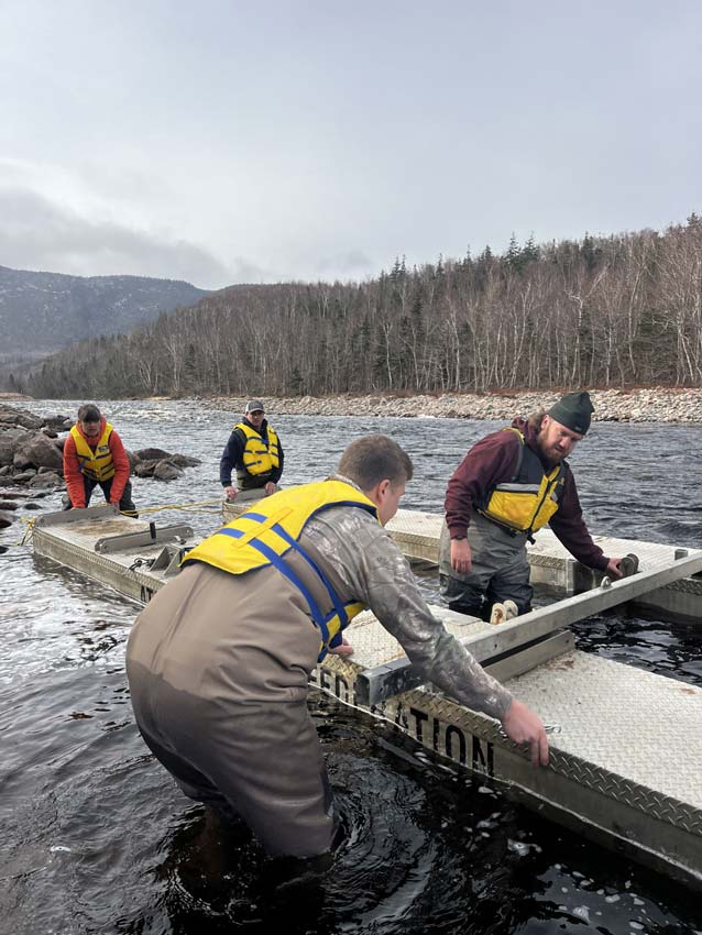 Luca Kordsmeyer, Stevie MacDonald-Campbell, Luke Burton, and Jillian Baker assemble a smolt wheel for deployment. Photo: Jordan Condon